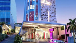 Un hotel de diseño moderno, con una entrada destacada y la dirección web claramente visible.