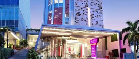 Un hotel de diseño moderno, con una entrada destacada y la dirección web claramente visible.