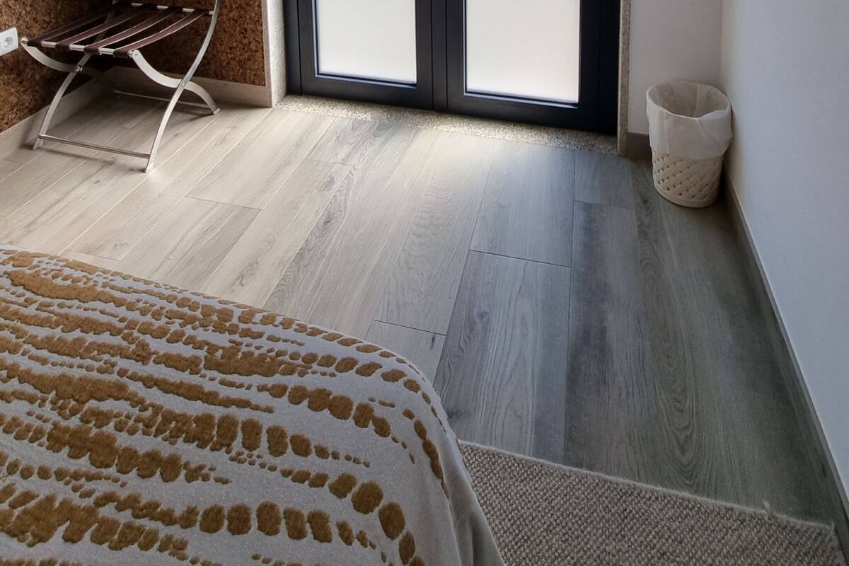 Ein Zimmer mit einem Bett, einem Fernseher, einer Schiebetür und einem kleinen Fenster.