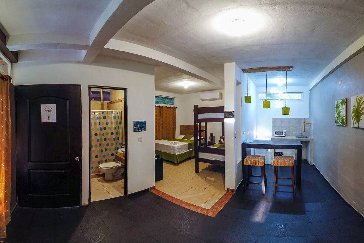 A hotel room with a bed, a desk, and a small seating area.
