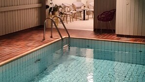 A swimming pool with clear water, surrounded by wooden panel walls and a tiled floor. - Karlskoga Hotell (Karlskoga)