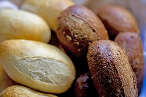 A close-up of various types of bread, including whole grain and white loaves. - Hotel Waldidyll (Ostseebad Baabe)