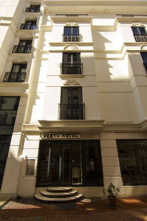 A hotel entrance with a sign reading "VERTU HOTEL."
