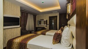 A hotel room with two beds, a TV, a desk, and a bathroom. - Vertu Hotel (Istanbul)