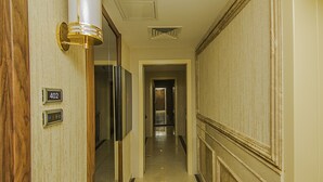 A hallway with a number sign, a light fixture, and a door. - Vertu Hotel (Istanbul)