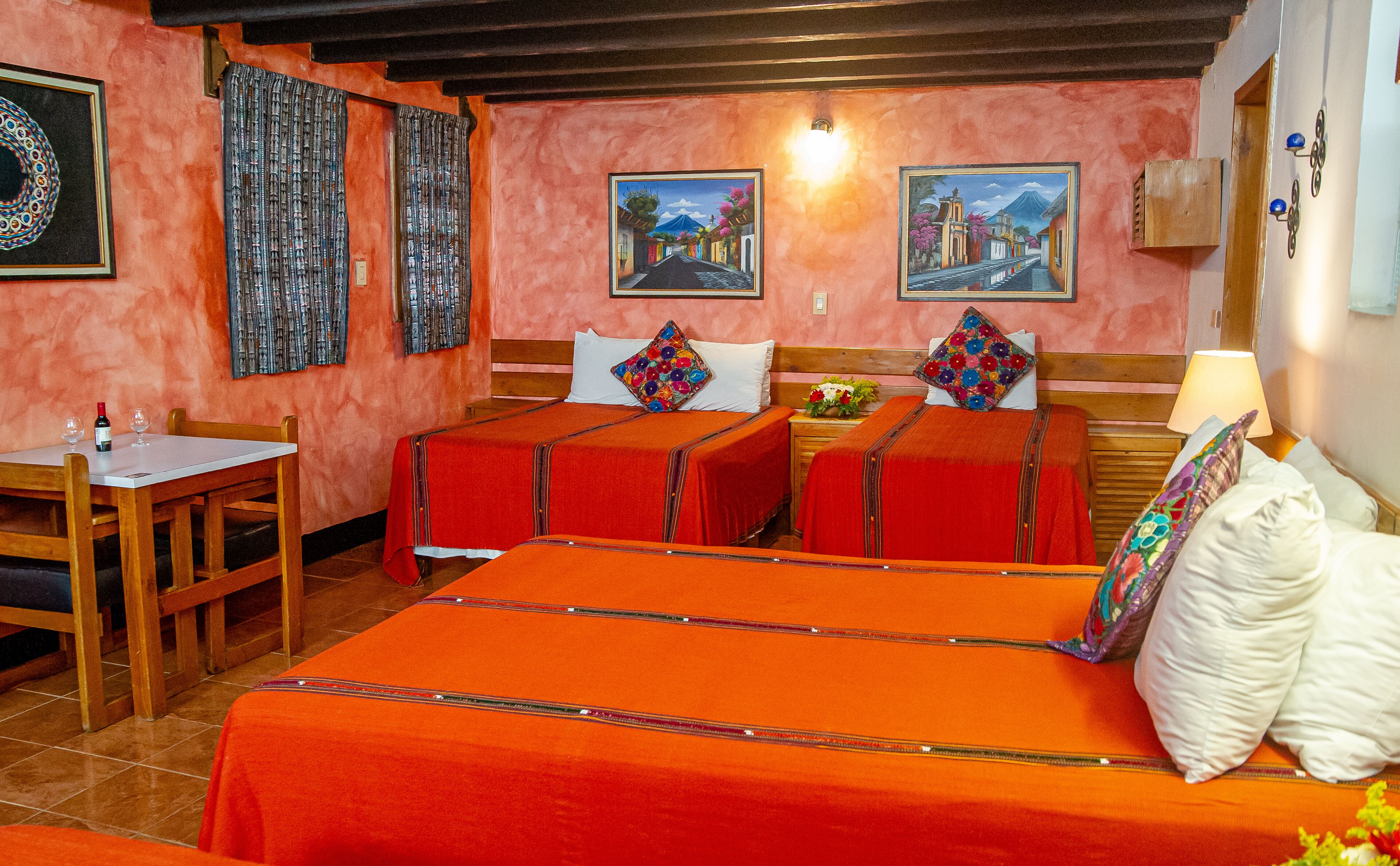 Una habitación de hotel con dos camas, una mesa de comedor y una silla.