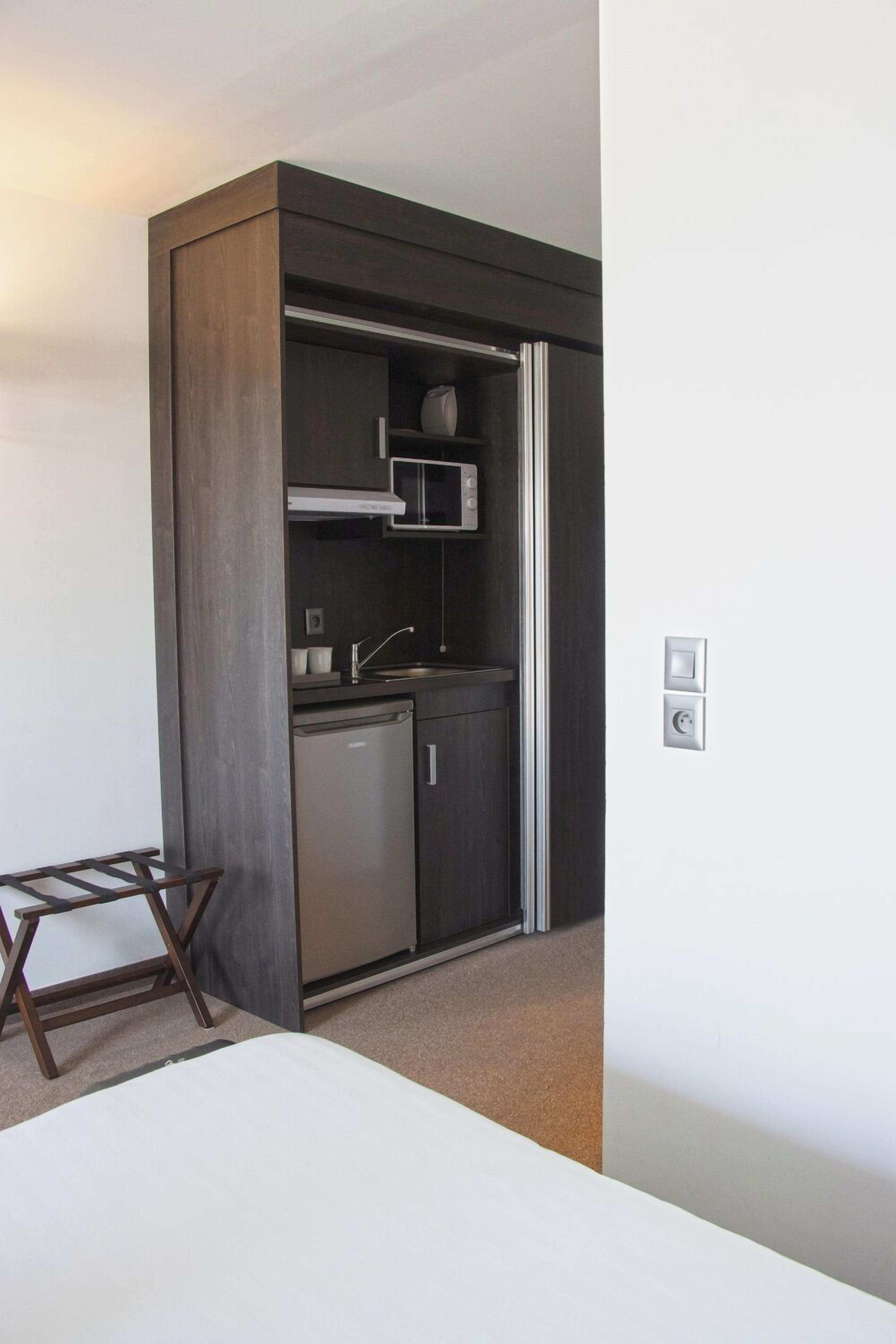 A compact kitchen with a built-in microwave, a sink, and a dishwasher.