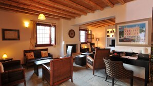 Una sala de estar acogedora con chimenea, asientos cómodos y un escritorio con computadora.