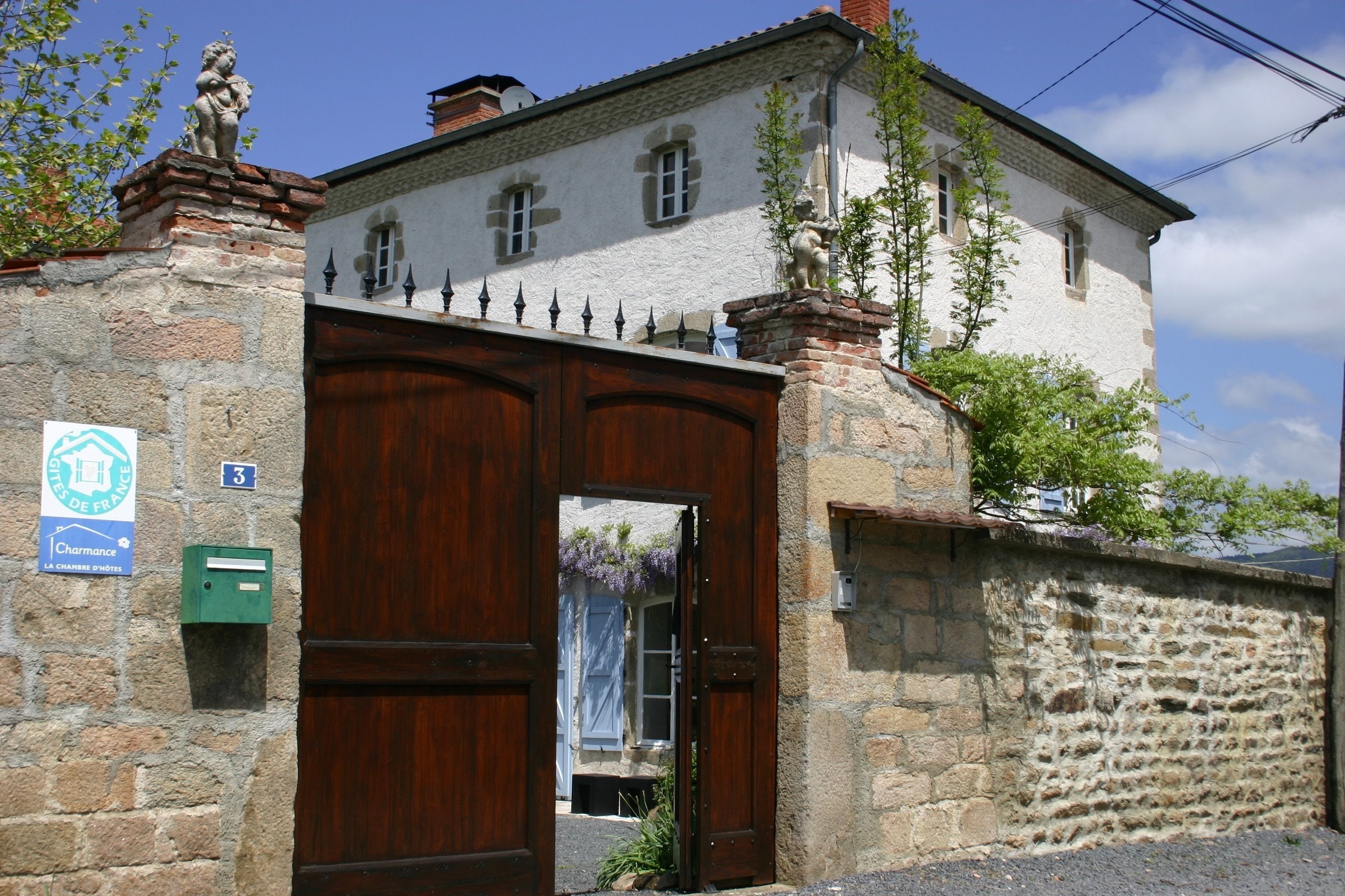 A stone building with a wooden door and a small window. There is a sign on the wall and a mailbox.