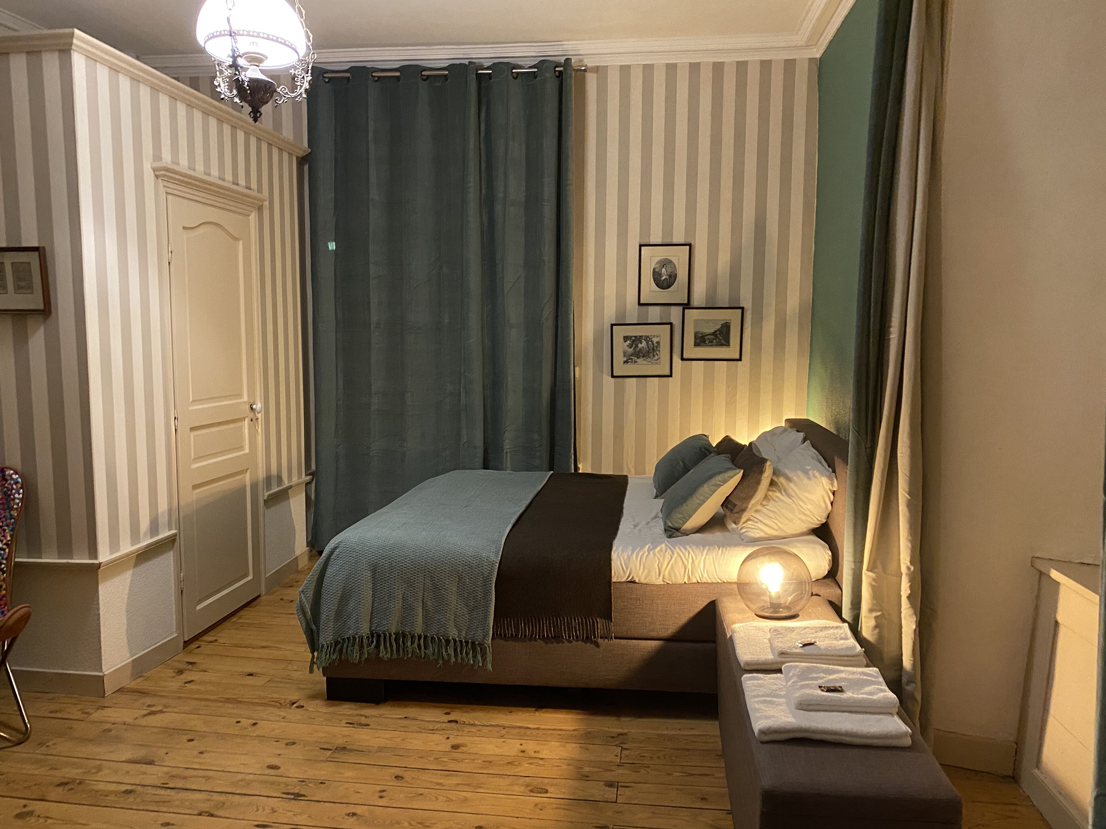 A neatly arranged bedroom with a bed, bedside table, and a chair.