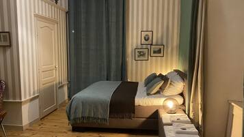 A neatly arranged bedroom with a bed, bedside table, and a chair.