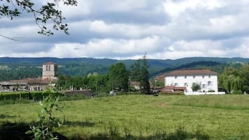 Paisatge rural amb una església, un edifici blanc i un camp.
