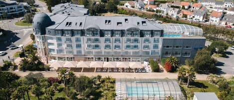 A hotel with multiple floors, a swimming pool, and a large dome structure.