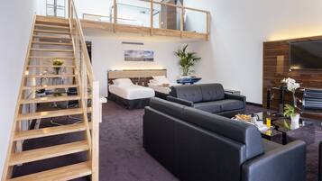 Een moderne hotelkamer met een hoogslaper, een bank, een salontafel en een televisie.