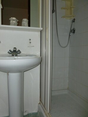 A bathroom with a white sink, a shower, and a mirror. - Hotel Jam Session (Les Deux Alpes)