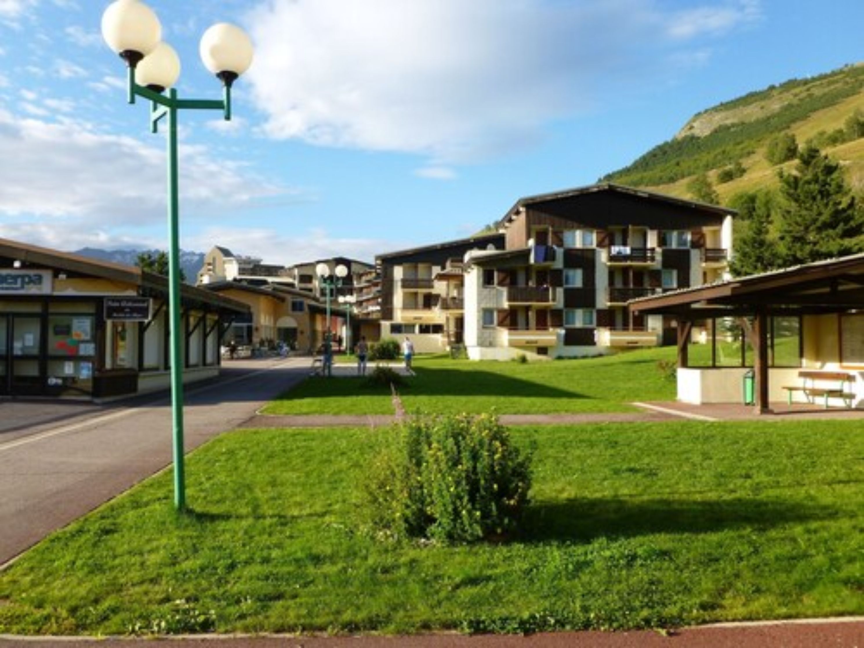 A hotel with multiple floors, outdoor seating areas, and a well-maintained lawn.
