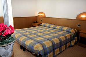 A hotel room with a bed, bedside tables, a lamp, and a vase of flowers. - Hotel Jam Session (Les Deux Alpes)