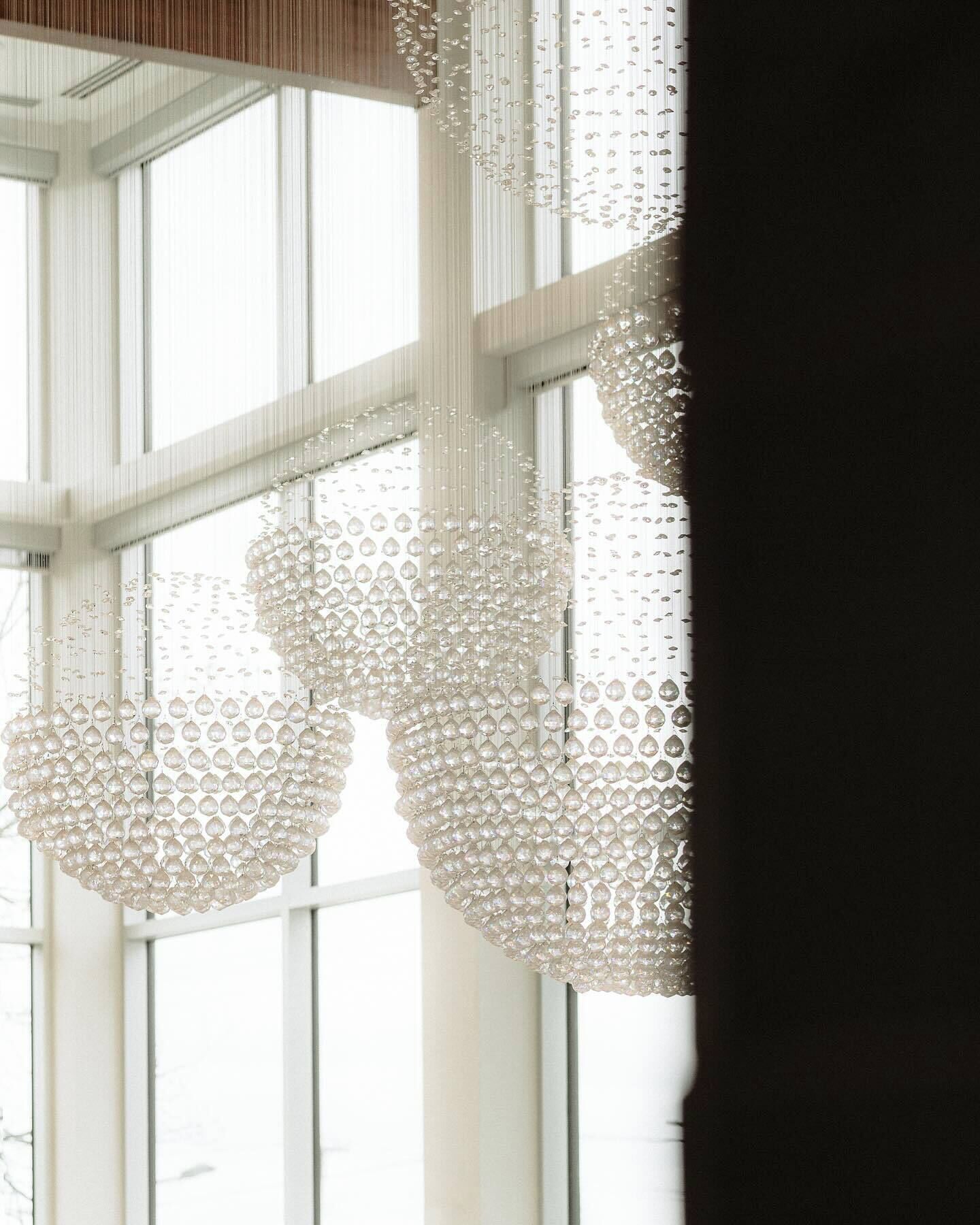A modern interior with large windows and decorative crystal chandeliers.