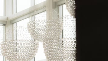 A modern interior with large windows and decorative crystal chandeliers.