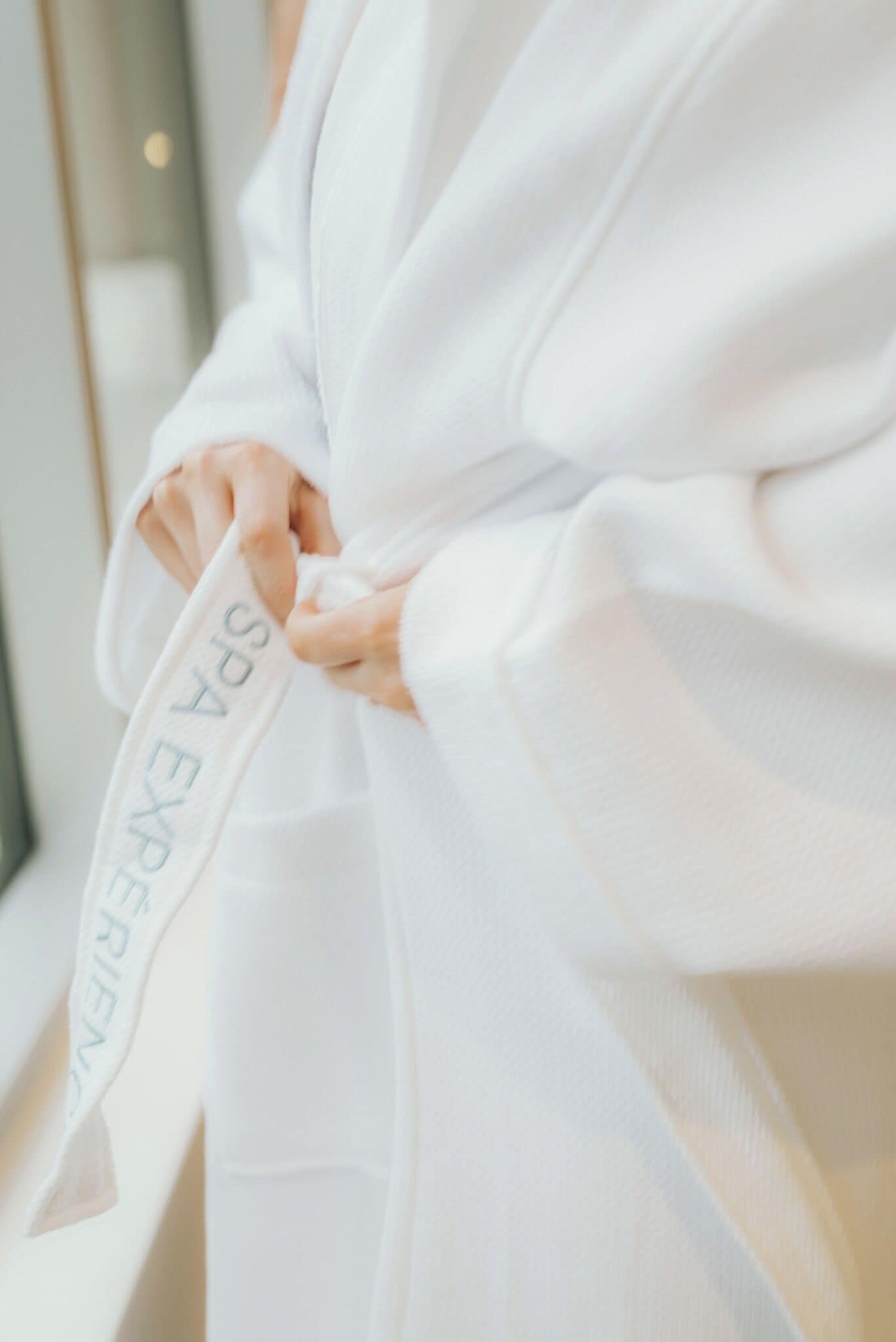 A person wearing a white robe with the text "SPA EXPERIENCE" on it.