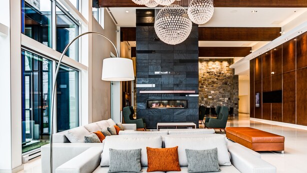 Una sala de estar moderna con un sofá grande, una chimenea y una pared de acento de piedra.