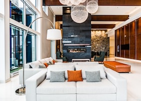 A modern living room with a large sofa, a fireplace, and a stone accent wall.