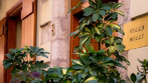 A building with a sign reading "Villa Milia" and a stone wall with a number "8" above a door. - Villa Milli (Chania)