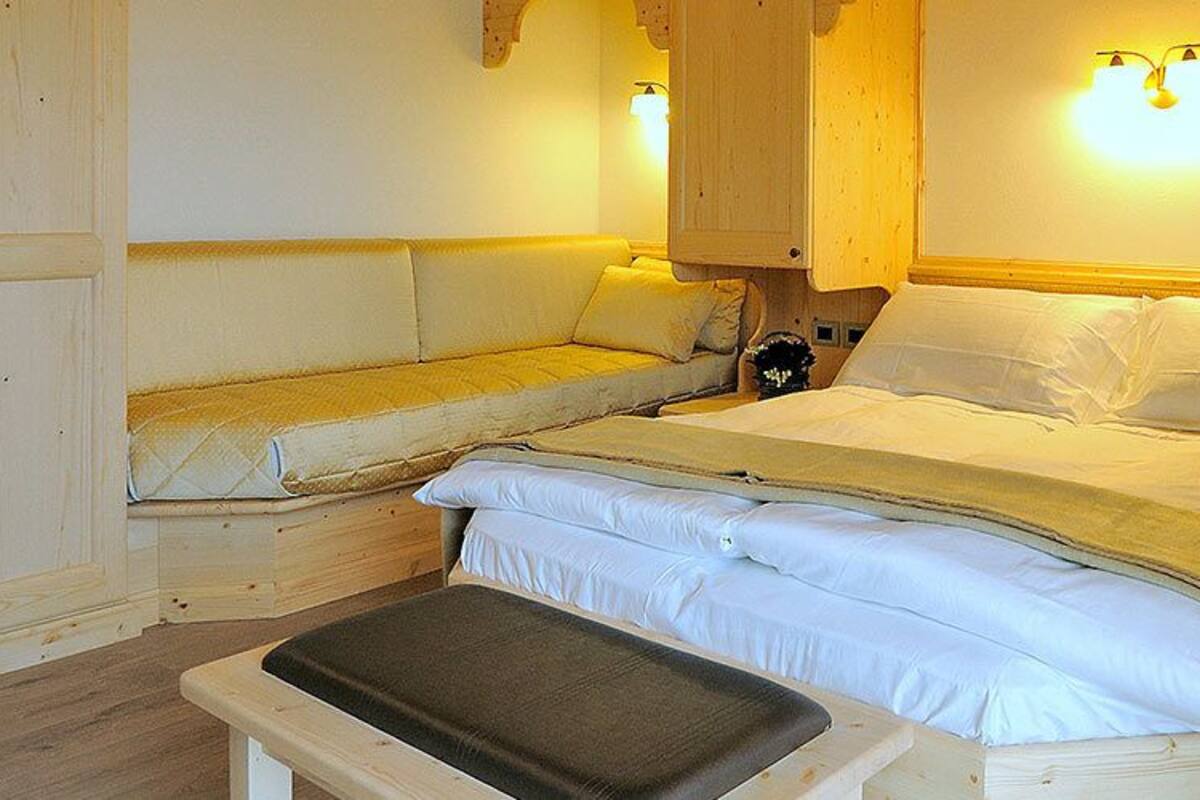 Une chambre confortable avec un lit, des tables de chevet et un banc.