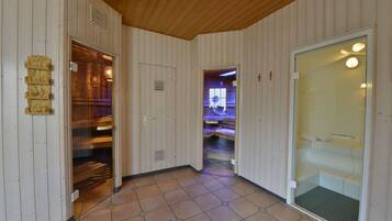 Un pasillo con paredes de madera y suelo de baldosas, que conduce a una habitación con cama y baño.