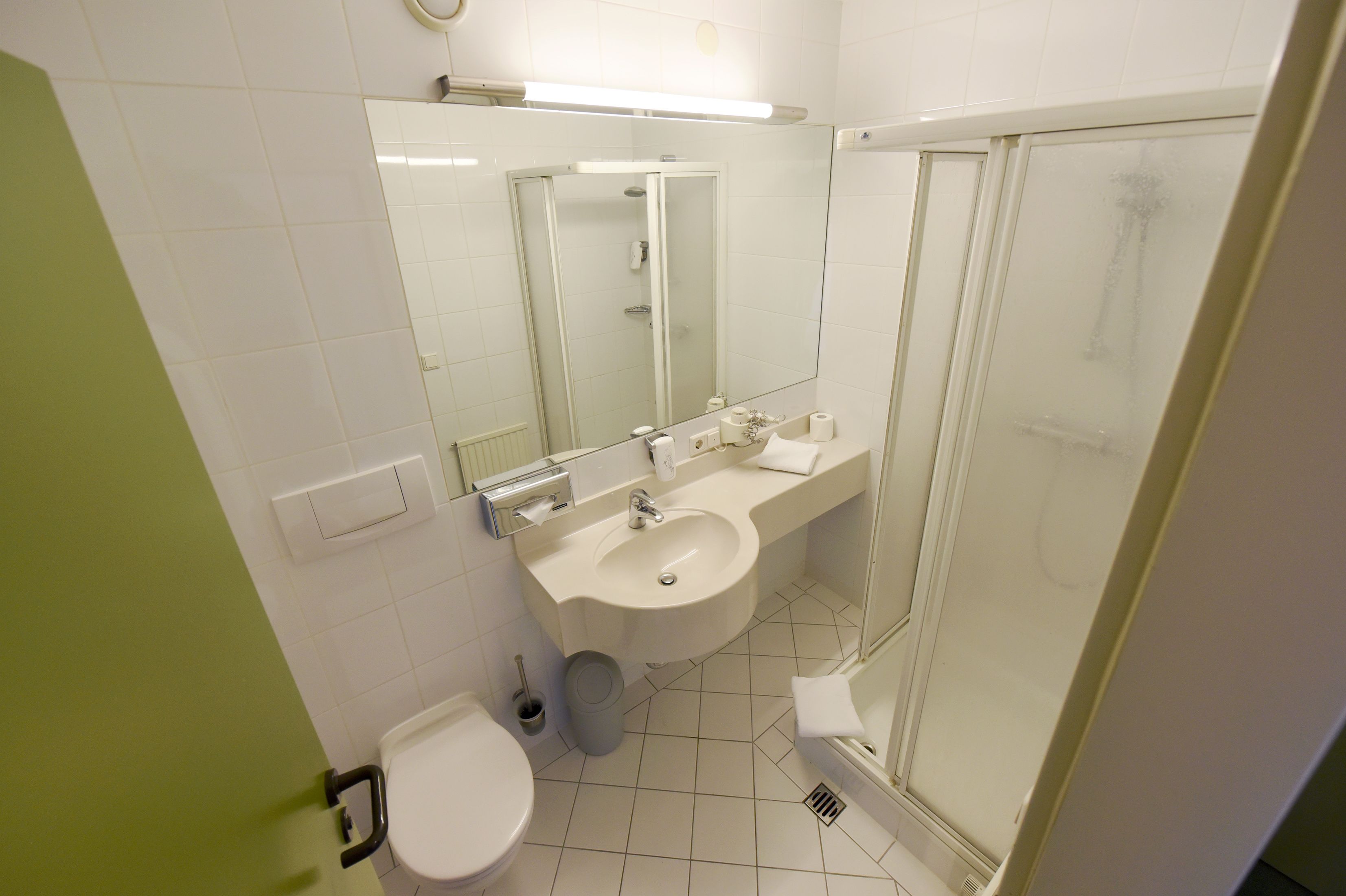 A modern bathroom with a toilet, sink, and shower.
