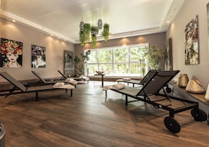 A spa room with multiple massage tables, large windows, and indoor plants. - Waldhotel Luise (Freudenstadt)