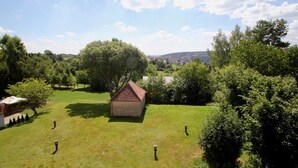 Une zone herbeuse avec un petit bâtiment et des arbres.
