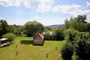 A grassy area with a small building and trees.
