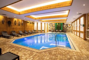 A swimming pool with a tiled floor and a wooden ceiling. - Waldhotel Luise (Freudenstadt)