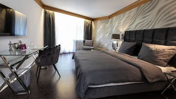 Une chambre d’hôtel moderne équipée d’un grand lit, d’un bureau, d’une chaise et d’un téléviseur.