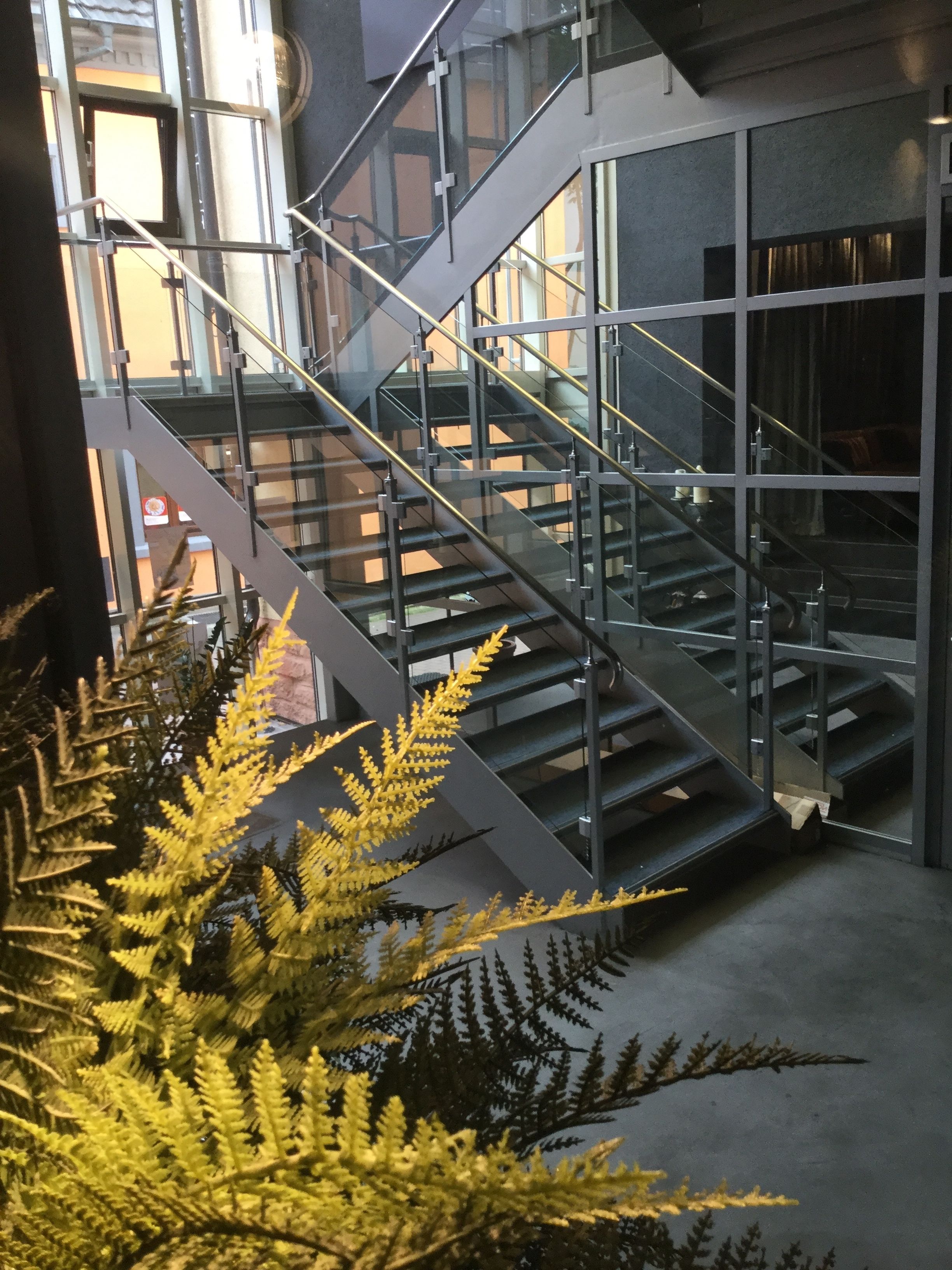 A modern building with a glass staircase and metal railings.