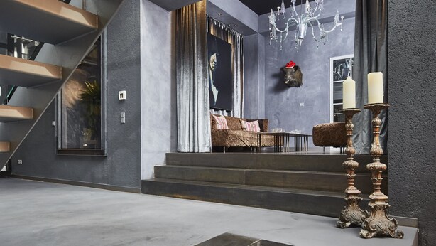 Ein modernes Interieur mit einer Treppe zu einem Wohnbereich, einer Kandelaber und einem dekorativen Kerzenhalter.