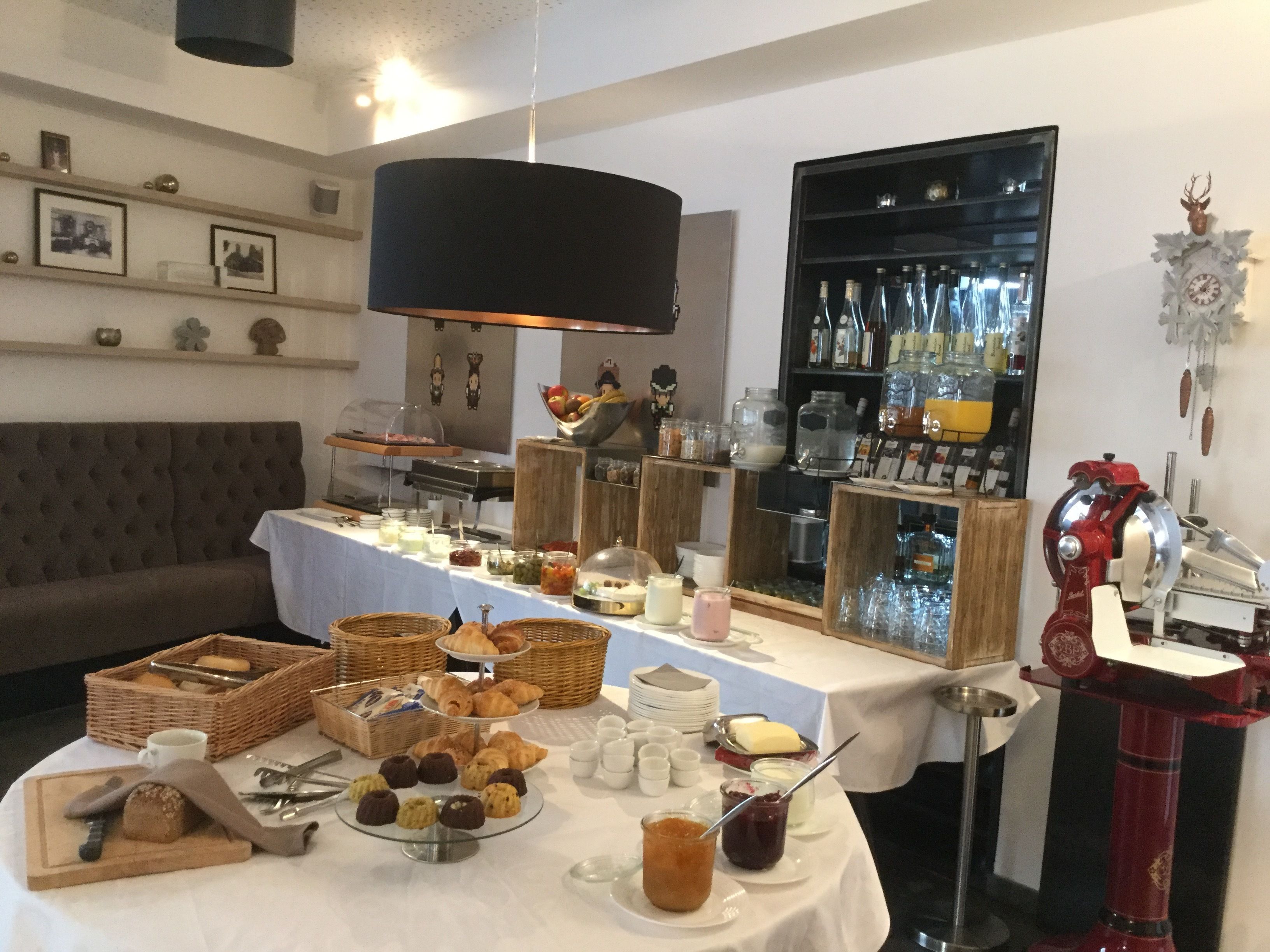 A buffet setup with various food items, a coffee machine, and a wine rack.