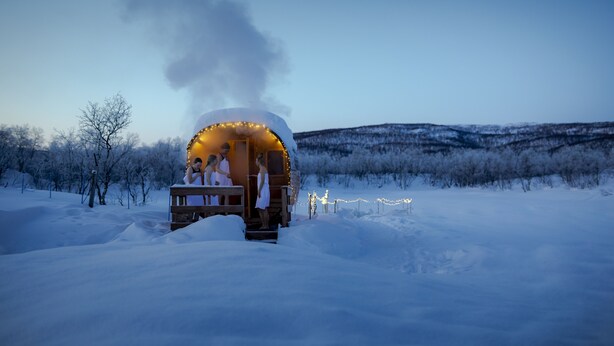 A snow-covered landscape with a wooden cabin emitting smoke.
