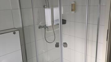 Ducha envidriada amb plat de dutxa i vàlvula de mà.
