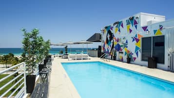 Una piscina al aire libre, sillones reclinables de piscina