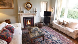 A living room with a fireplace, a television, and a sofa. - Ellesmere House (Castle Cary)