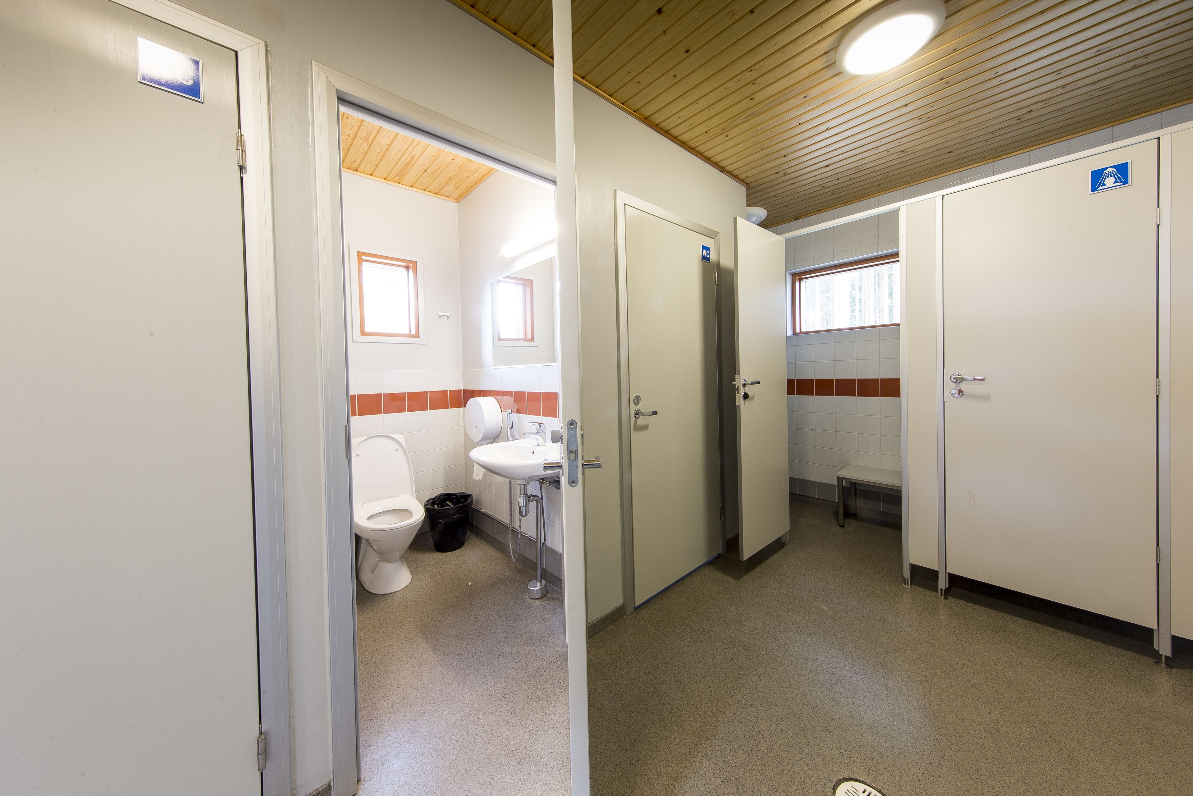 Des toilettes publiques comprenant des toilettes, un lavabo et une poubelle.
