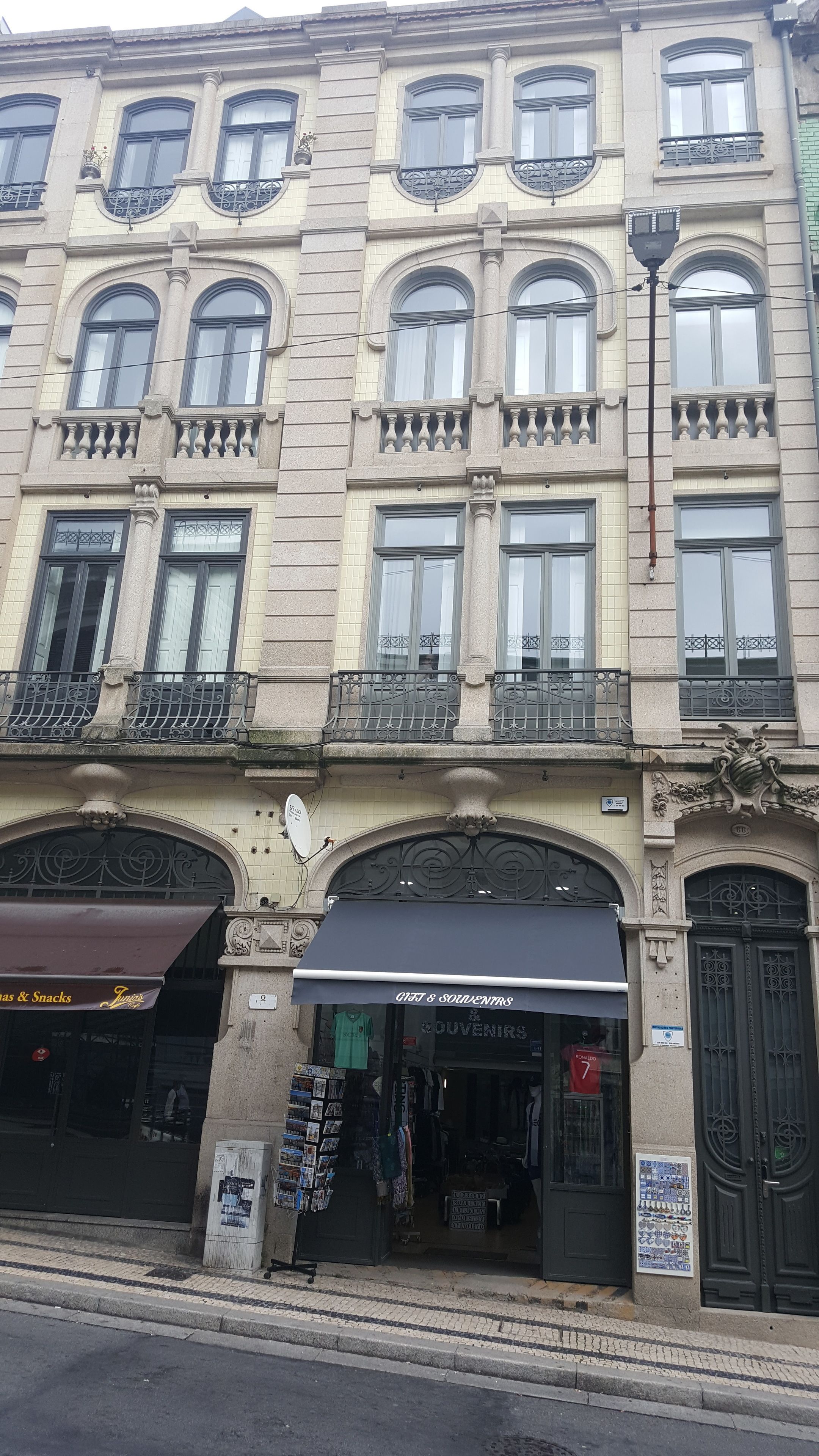 A multi-story building with a ground-floor shop selling souvenirs and snacks.