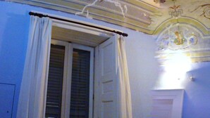 A room with a closed window, a door, and a ceiling with decorative moldings. - B&B Casa Cavalli (Lucera)