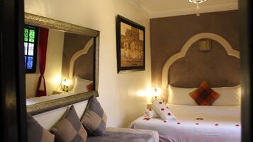 Une chambre d’hôtel avec un lit, un canapé, un miroir et un tableau au mur.
