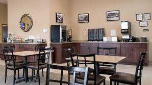 A hotel lobby with a reception desk, seating area, and wall-mounted amenities. - Cornerstone Inn & Suites (Oelwein)