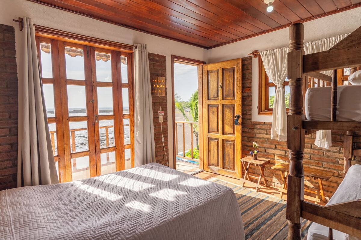 Una habitación con una cama grande, muebles de madera y vistas al exterior.