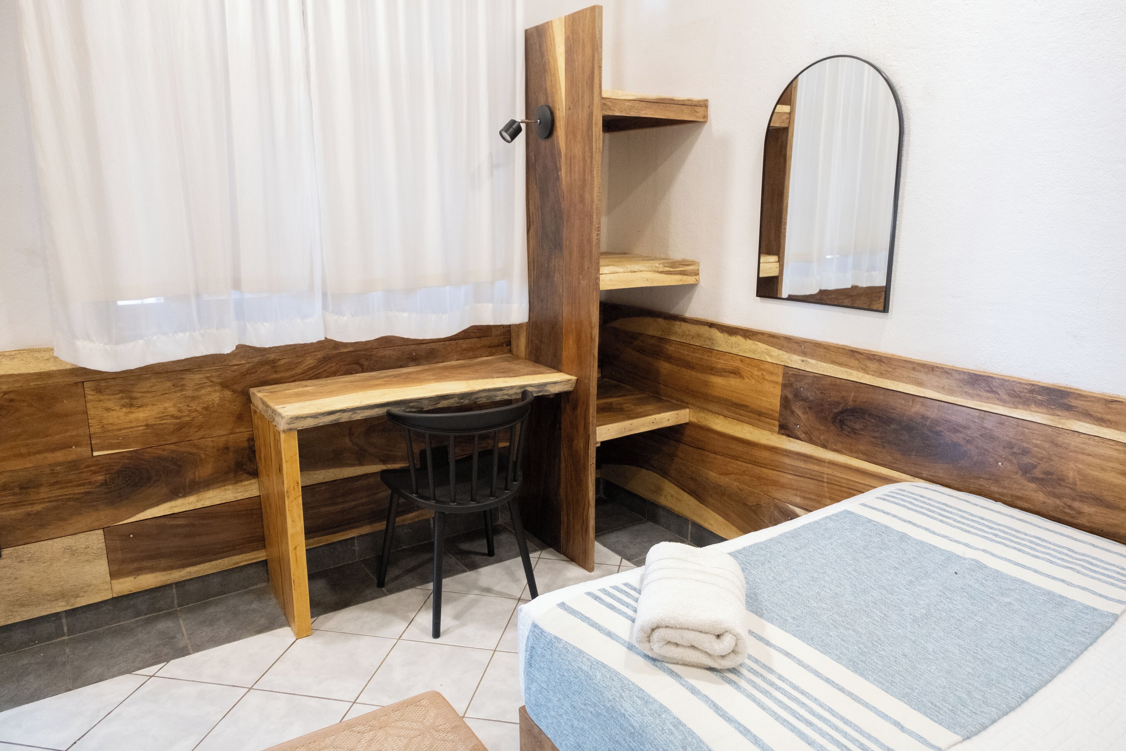 A room with a bed, a desk, and a chair.