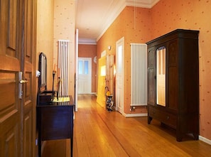 Enter a cozy room with a radiator and cabinet, featuring a door with a brass handle and a lamp on the floor.